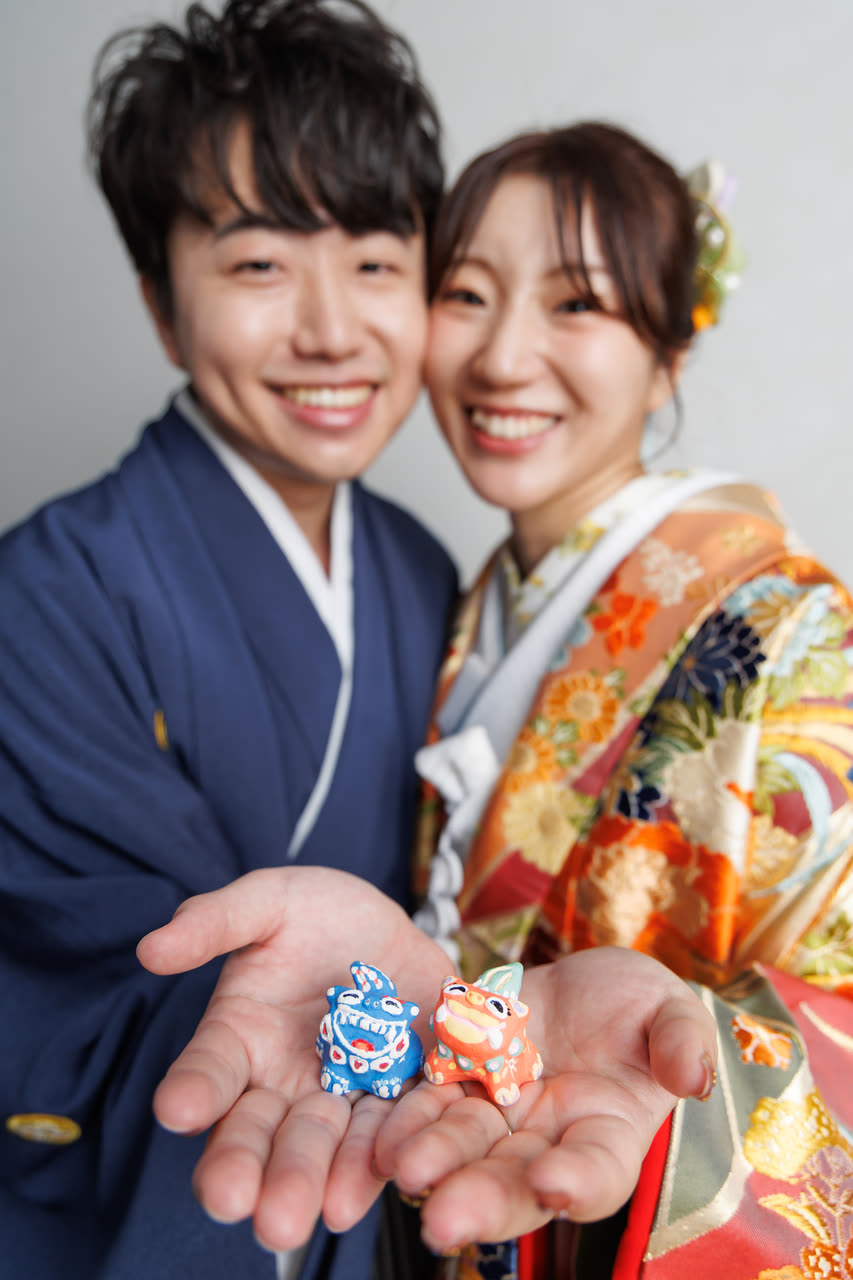 シーサーを手のひらにのせた和装のふたり