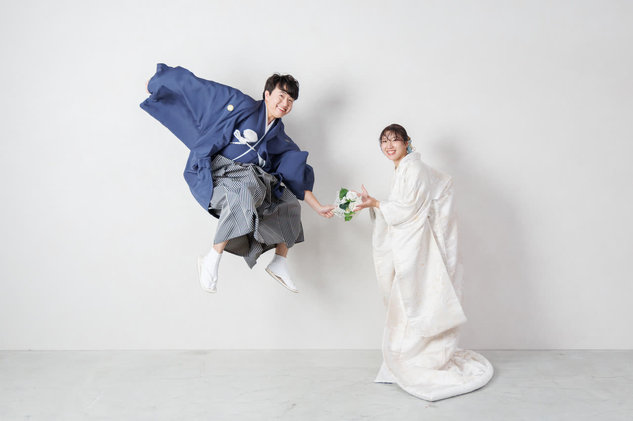 ジャンプする新郎と和装の新婦